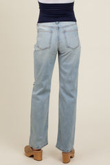 woman wearing light blue maternity jeans, seen from the back, with a fitted top and wooden clogs