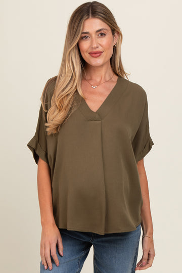 woman wearing an olive green short sleeve maternity top with a v-neck and relaxed fit
