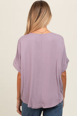 woman wearing a lavender maternity top with rolled sleeves, shown from the back