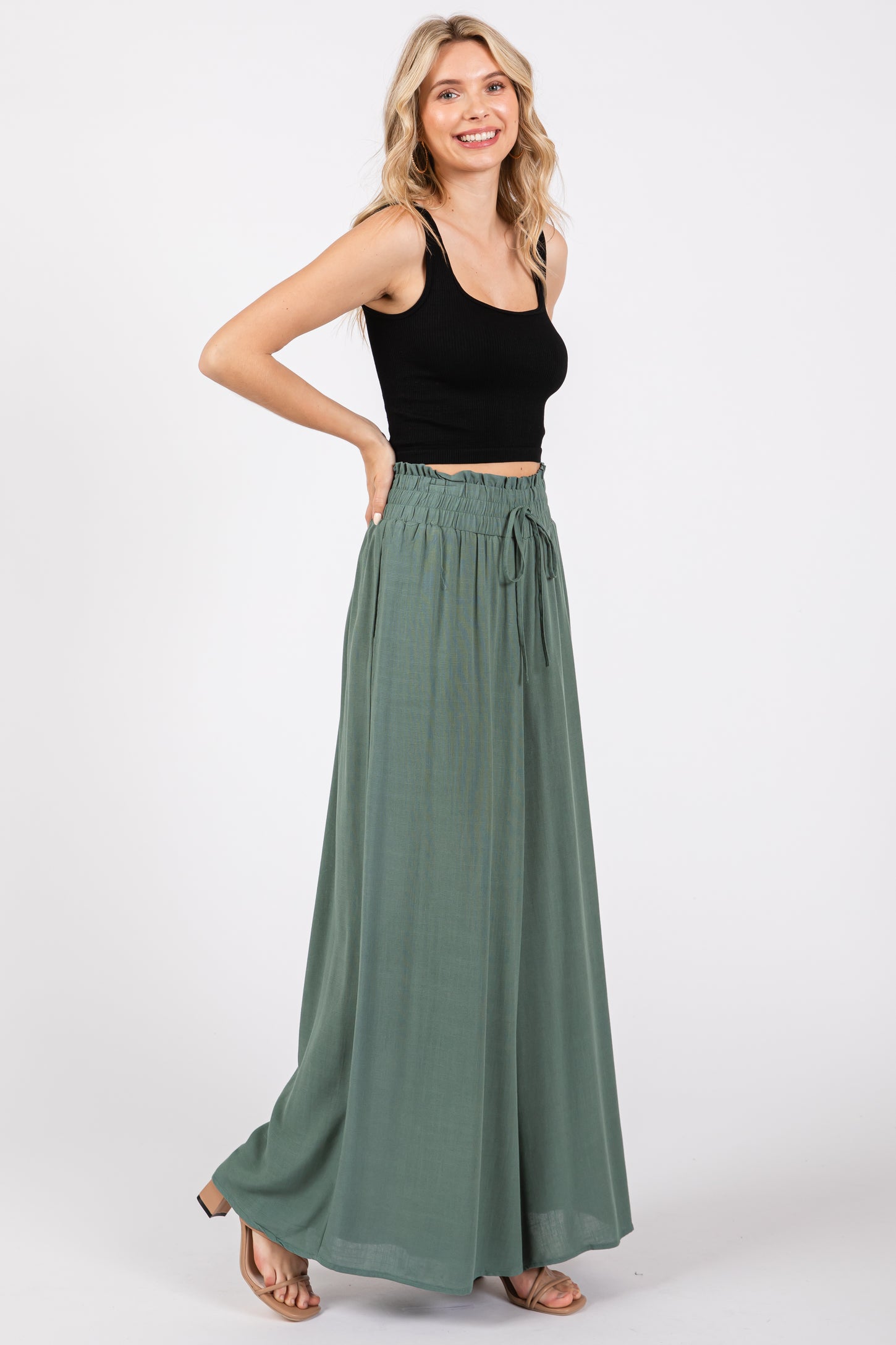woman wearing a black crop top and a long olive green maxi skirt with an elastic waist and drawstring