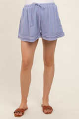 woman wearing light blue maternity shorts with an elastic waistband and ruffled hem
