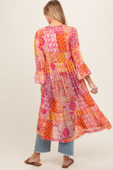 woman wearing a colorful floral patterned maternity maxi dress with bell sleeves and a flowy silhouette