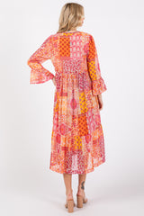 woman wearing a colorful patchwork maxi dress with bell sleeves, viewed from the back