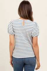 woman wearing a striped maternity top with puff sleeves and a keyhole back detail, viewed from the back