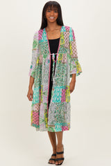 woman wearing a colorful patterned lightweight kimono with bell sleeves over a black dress