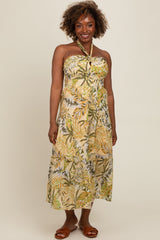woman wearing a strapless maxi dress with a tropical leaf print in green and yellow