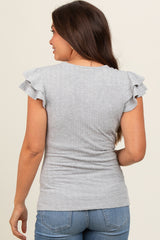 woman wearing a gray maternity top with ruffle sleeves and a fitted style, showing a side view