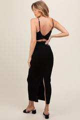 woman wearing a black maternity two-piece set with a cropped top and a long skirt featuring a side slit