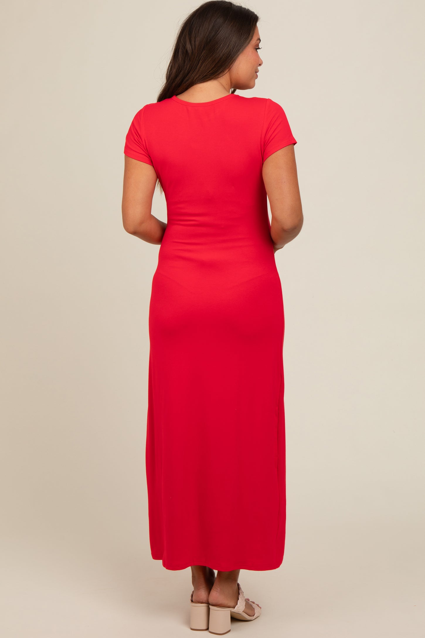 woman wearing a red short sleeve maternity maxi dress, view from the back