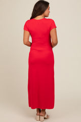 woman wearing a red short sleeve maternity maxi dress, view from the back
