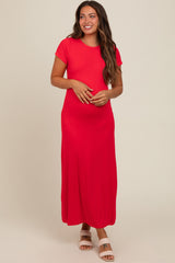 woman wearing a bright red short sleeve maternity maxi dress and cradling her baby bump