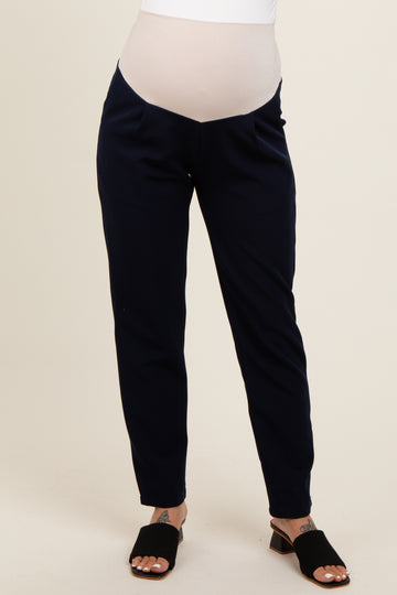 woman wearing navy blue maternity pants with a stretchy over-belly panel and stylish ankle-length cut