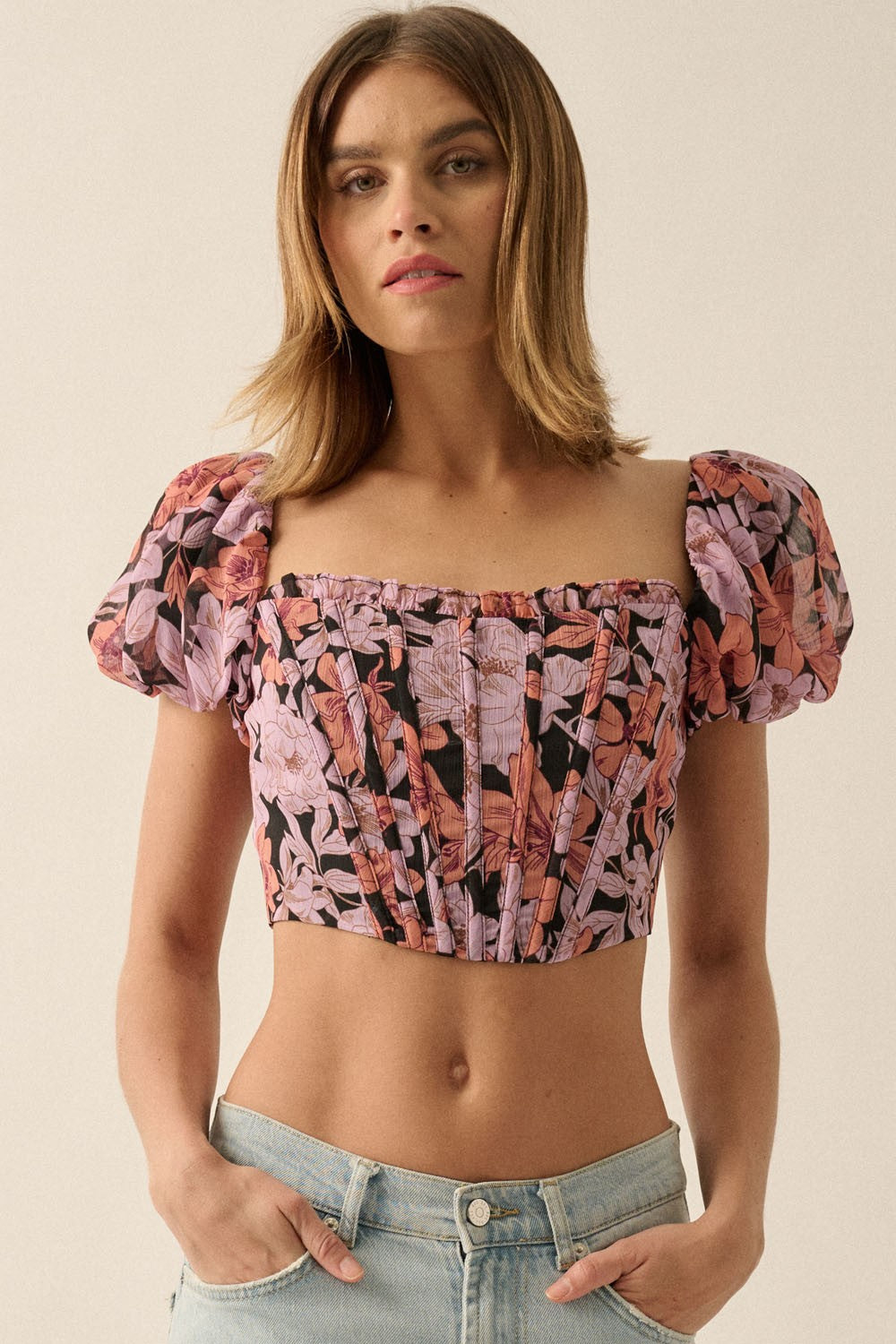 woman wearing a black floral crop top with puffed sleeves and a square neckline