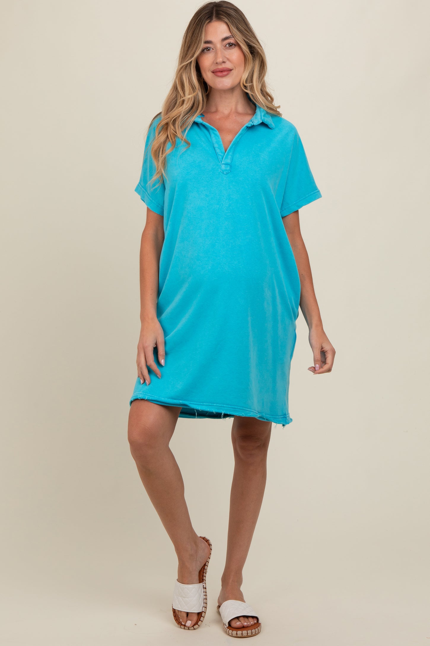 woman wearing a bright blue maternity polo dress with short sleeves and a relaxed fit, showing her baby bump
