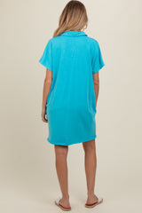 woman wearing a turquoise maternity dress with short sleeves and a loose fit, viewed from the back