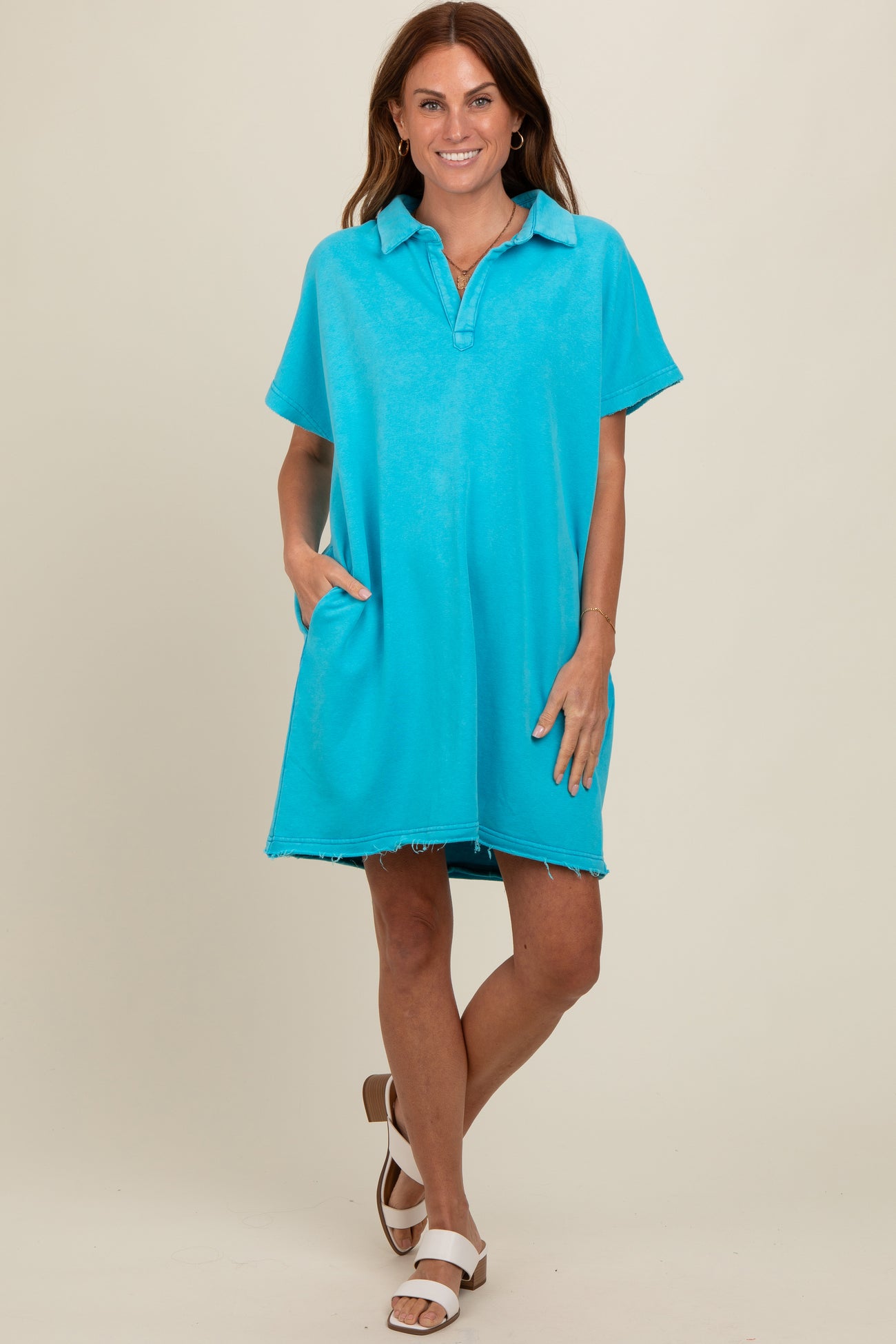 woman wearing an aqua blue short sleeve polo dress with a relaxed fit and side pockets