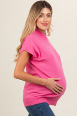 woman wearing a bright pink short sleeve maternity top and holding her baby bump