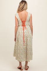 woman wearing a floral print maternity dress with a lace-up back detail and a flowing midi length