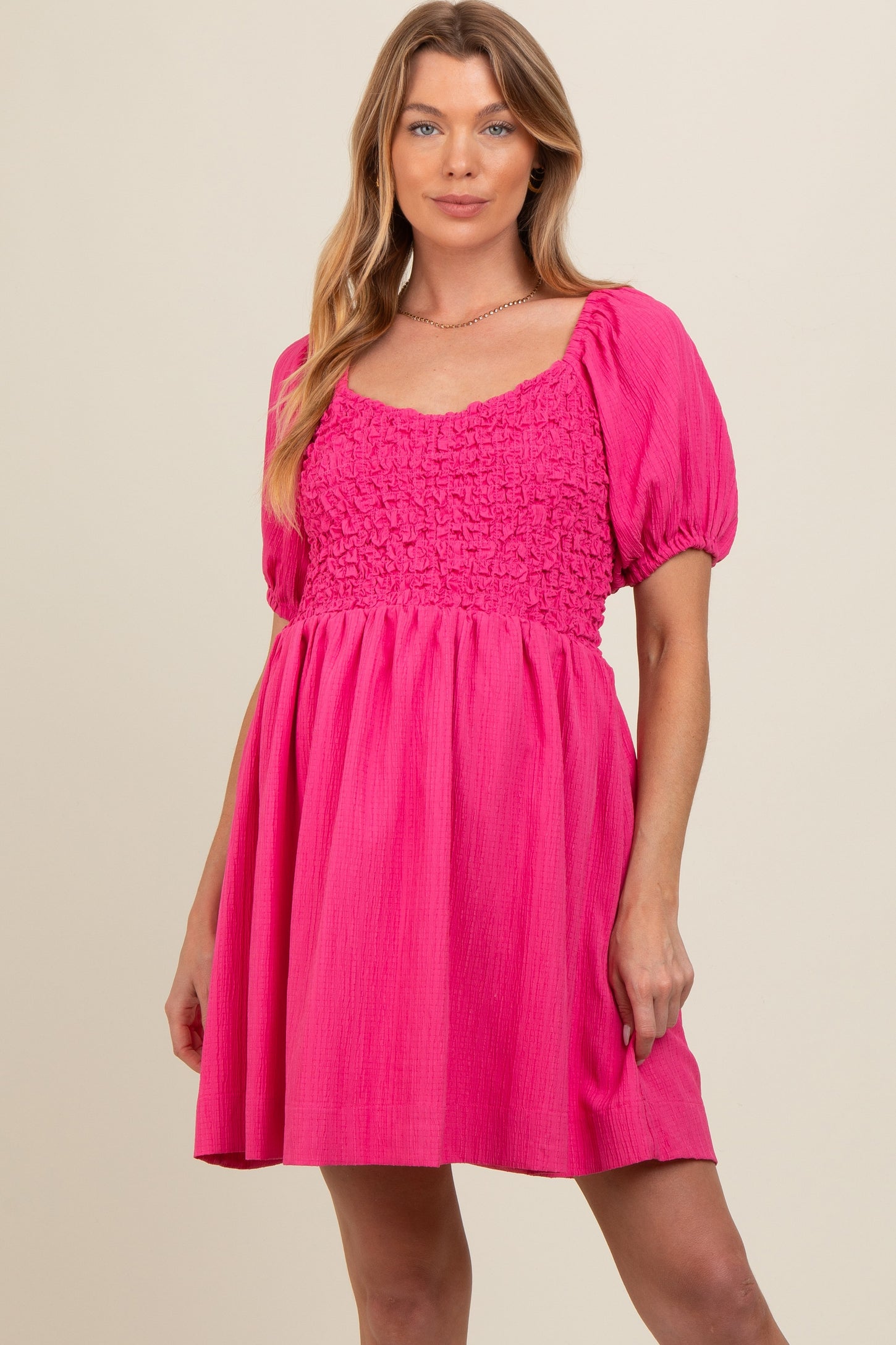 woman wearing a vibrant pink maternity dress with puff sleeves and a square neckline