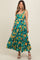 woman wearing a floral print maternity dress in teal and yellow with a ruffled hem and spaghetti straps, baby bump visible