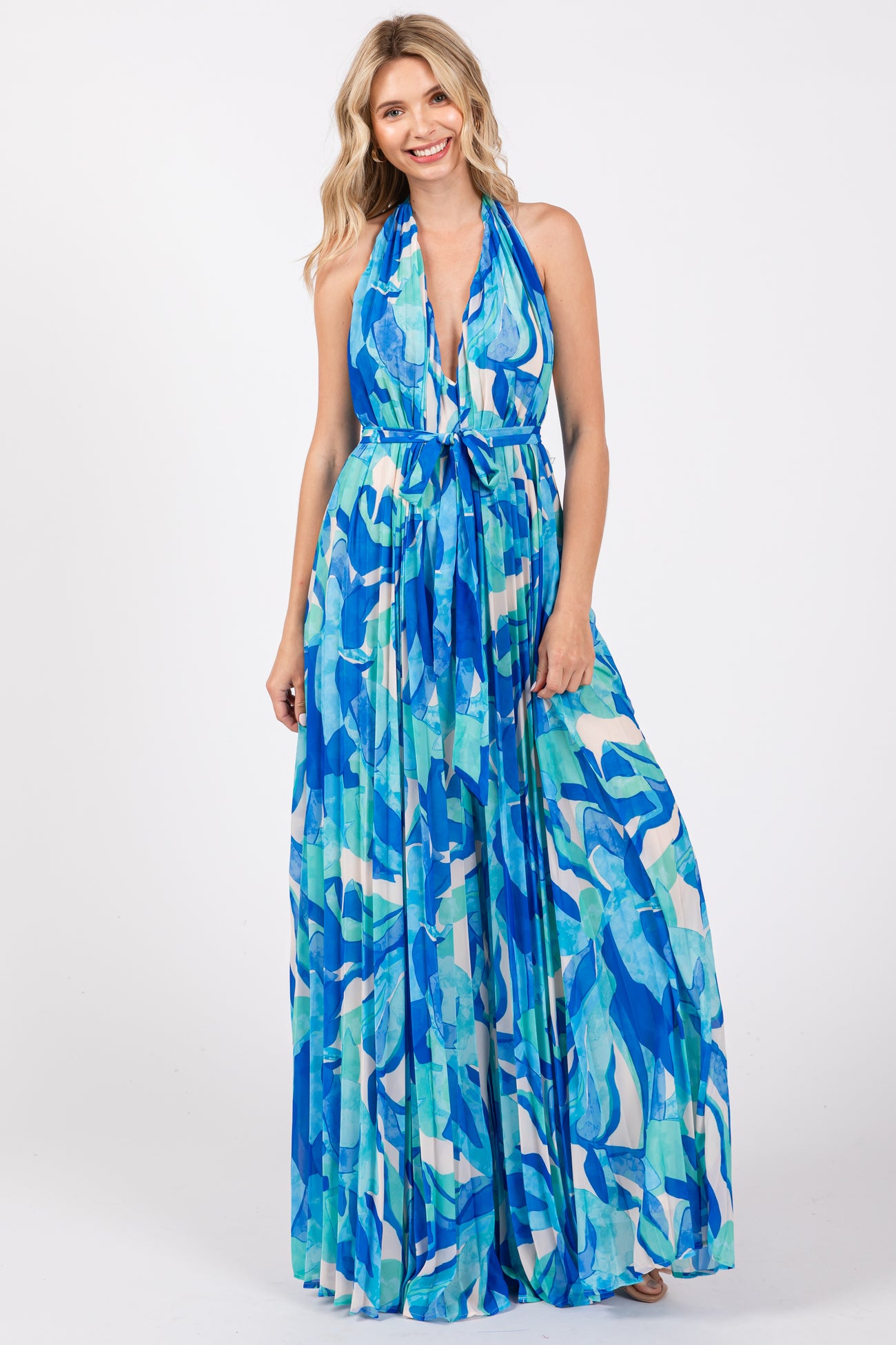 woman wearing a blue and green halter neck maxi dress with a tie waist detail