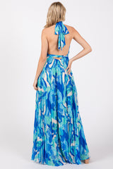 woman wearing a blue floral maxi dress with a halter neck and open back design