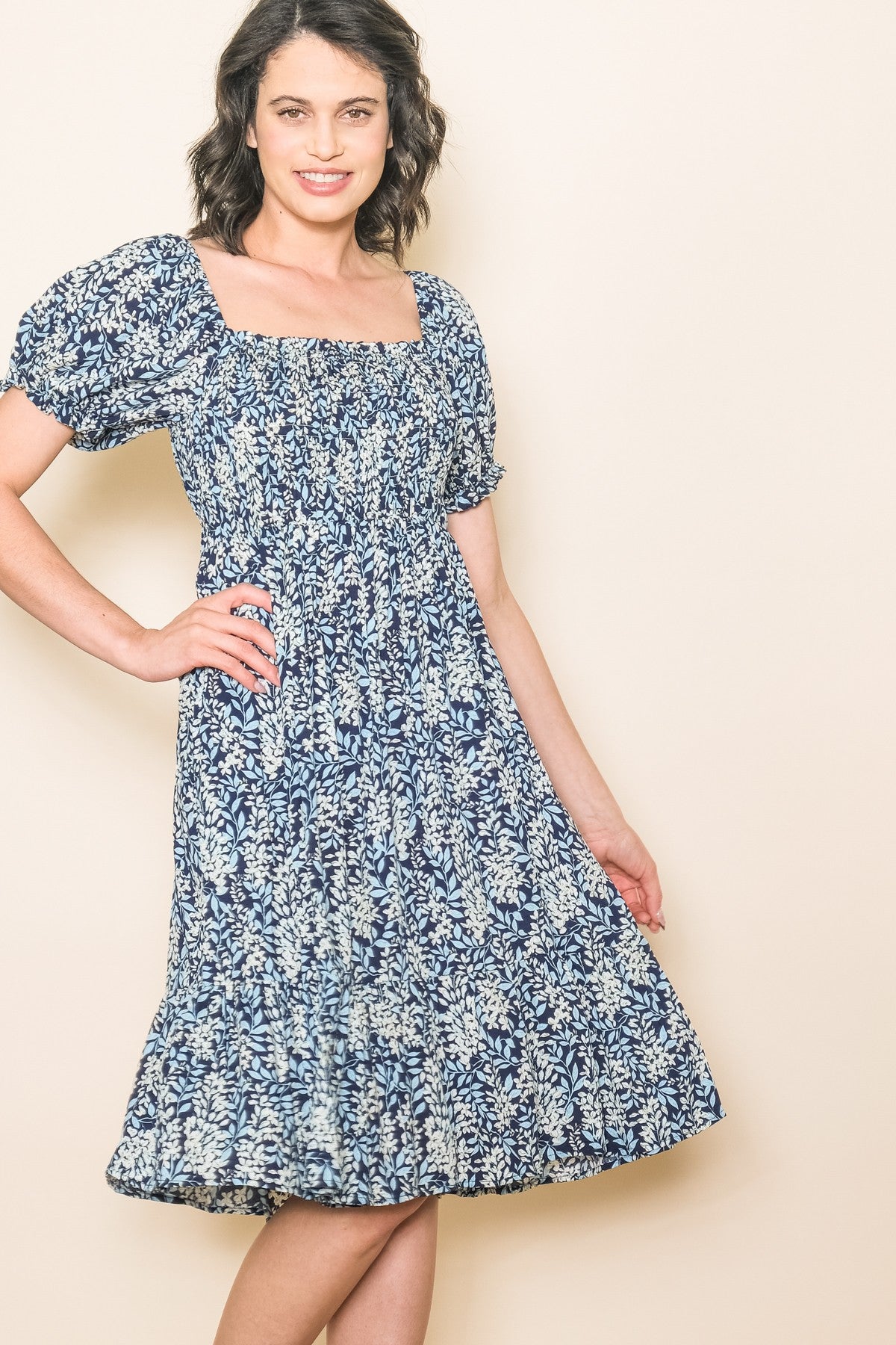 woman wearing a navy blue floral print midi dress with puff sleeves and a square neckline