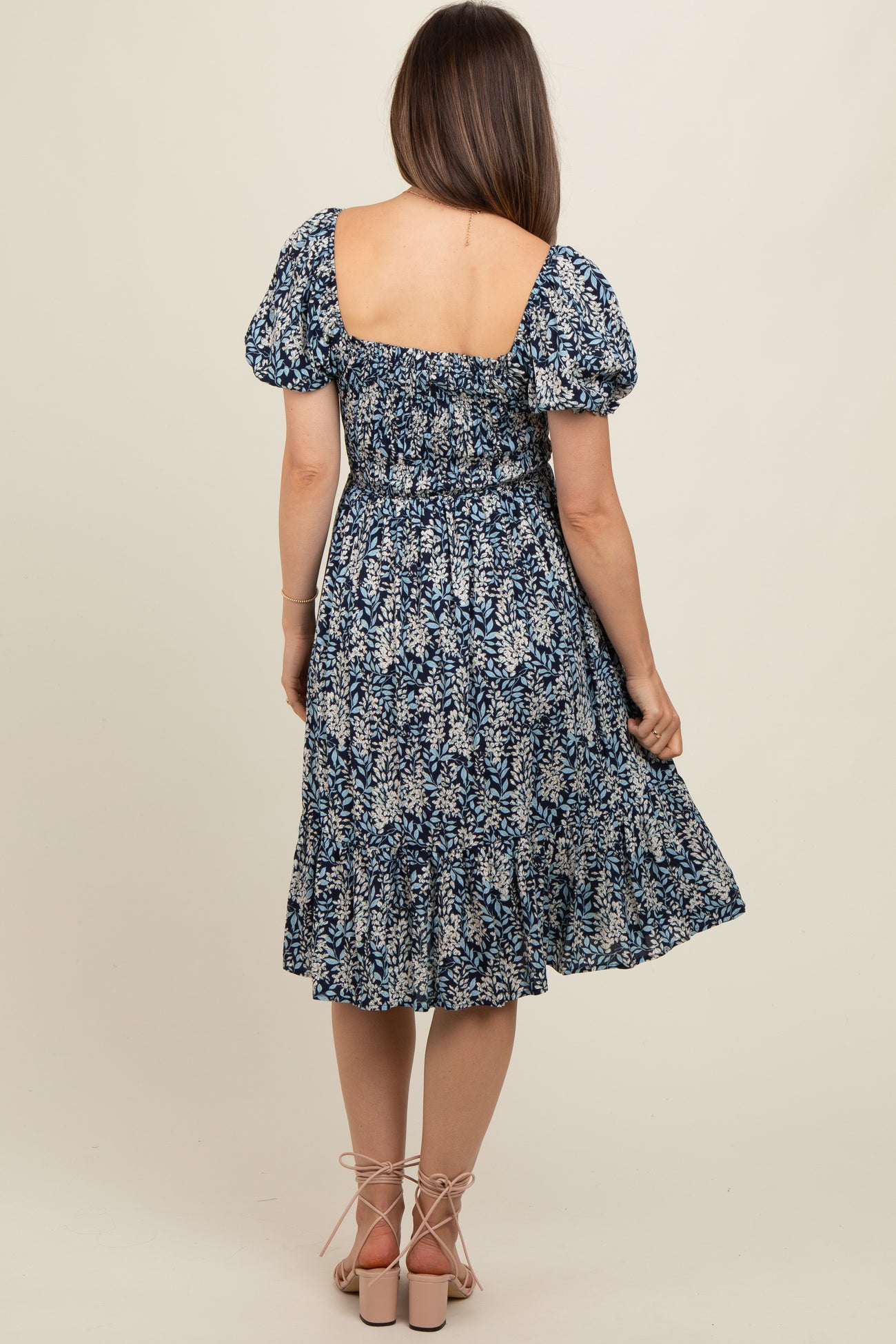 woman wearing a floral print maternity dress with puff sleeves and a smocked back, showing a relaxed fit