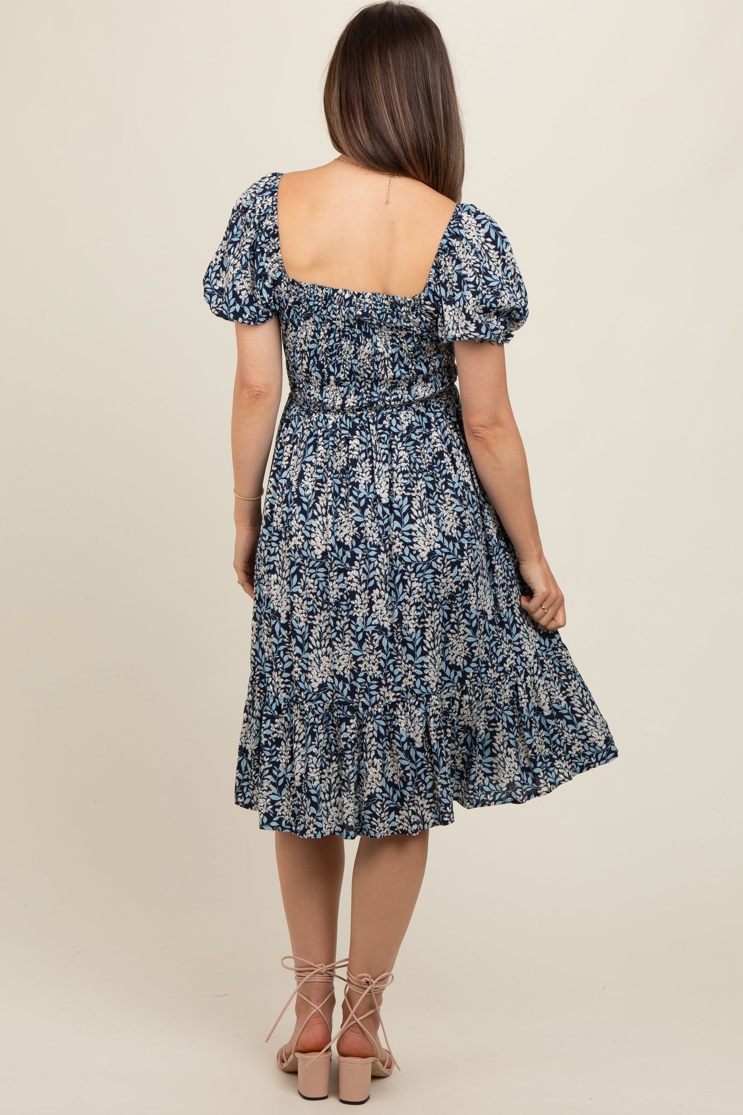 woman wearing a floral print maternity dress with puff sleeves and a smocked back, showing a relaxed fit