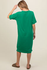woman wearing a green short sleeve maternity dress, view from the back, relaxed fit, knee-length