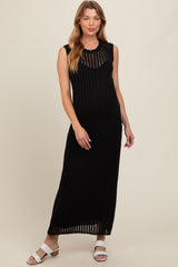 woman wearing a black ribbed maternity maxi dress with sleeveless design and a visible baby bump