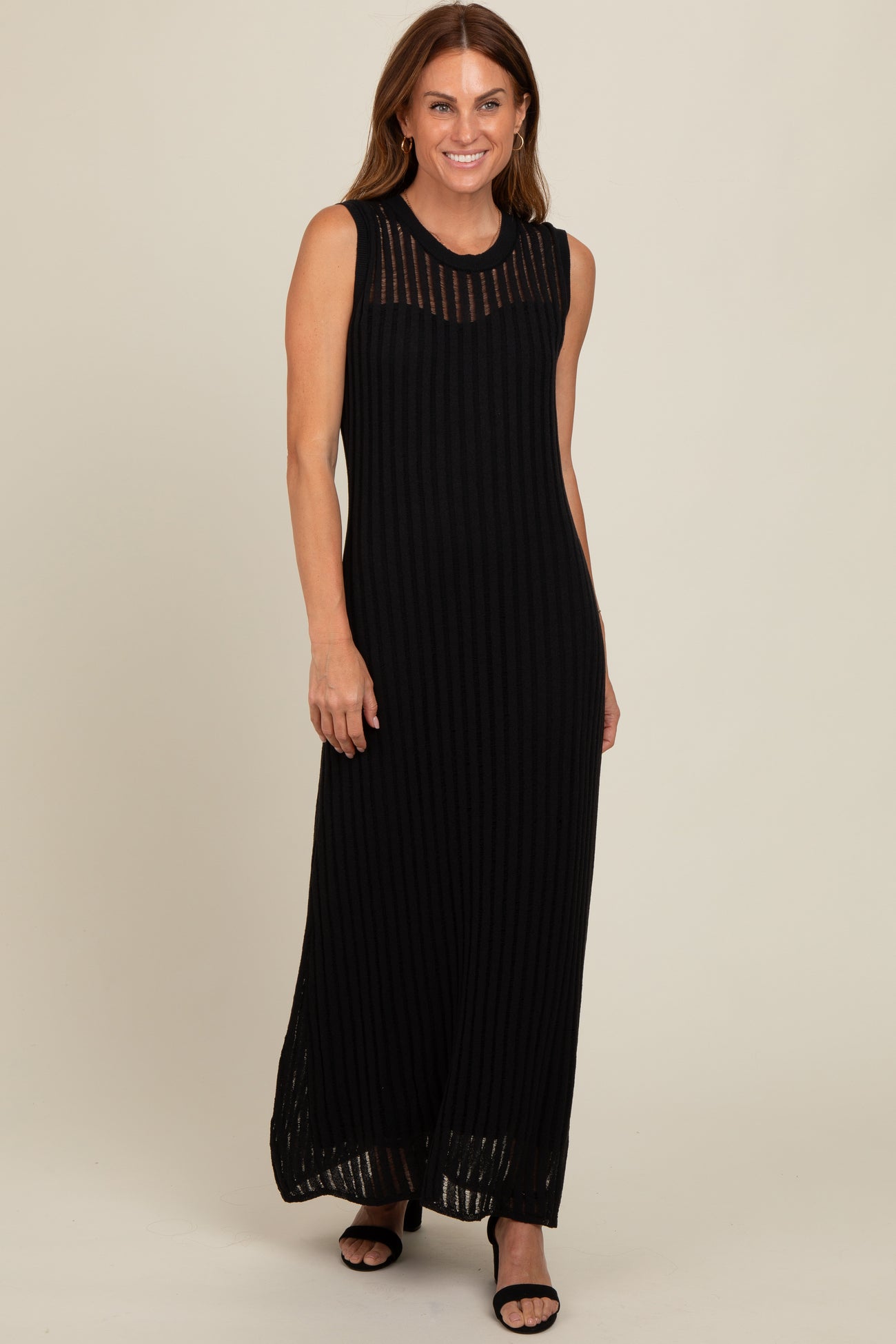 woman wearing a black ribbed maxi dress with a sheer striped neckline and side slits