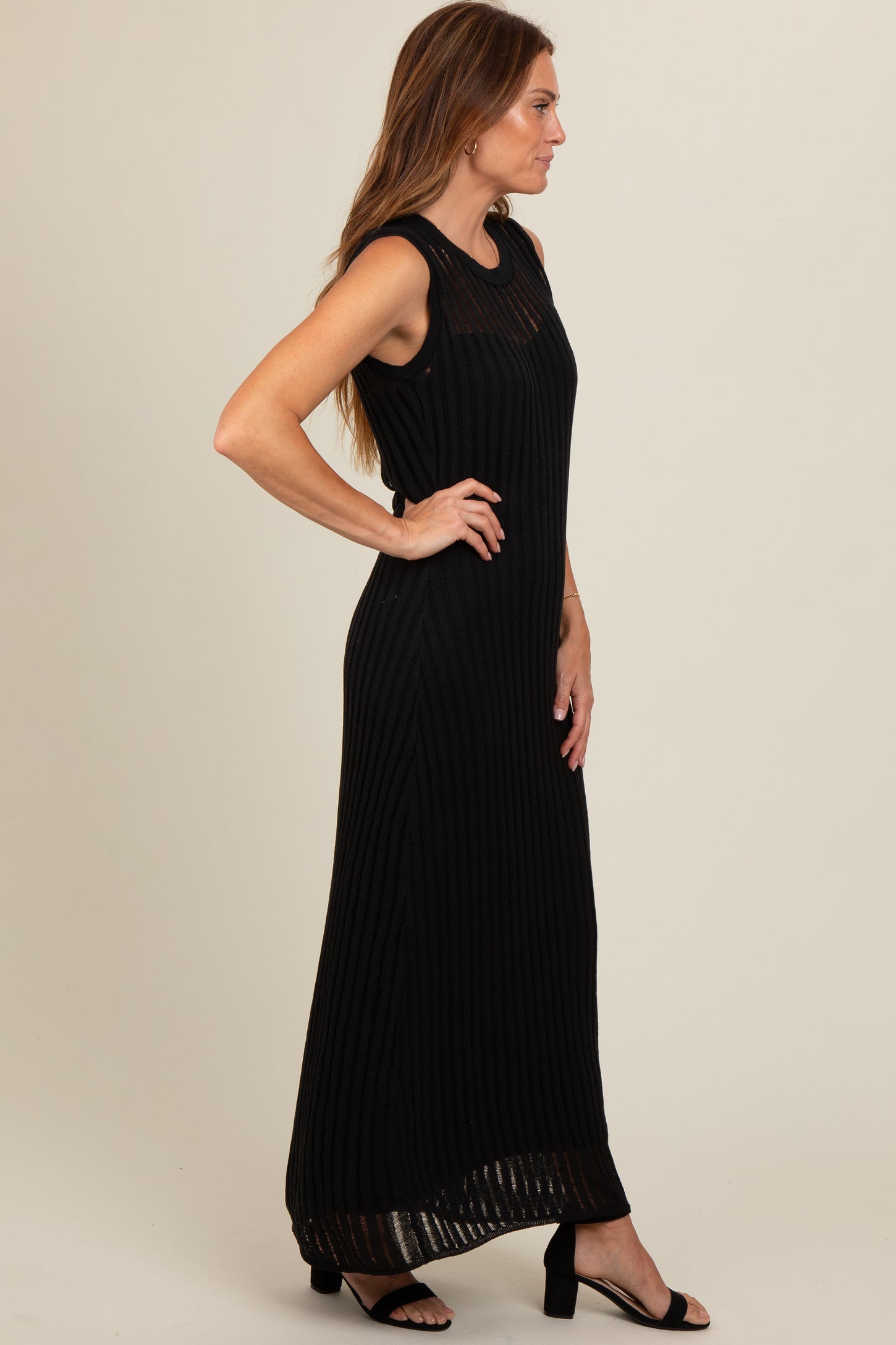 woman wearing a black sleeveless maxi dress with vertical stripes and a relaxed fit