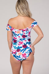 woman wearing a floral print maternity swimsuit with off-the-shoulder sleeves, showing a fitted design from the back