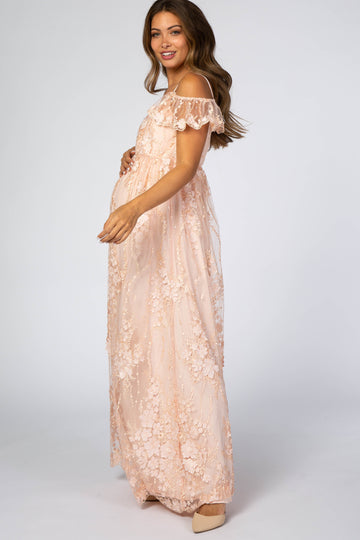 pregnant woman in a light pink floral lace maternity maxi dress with off-the-shoulder ruffle sleeves