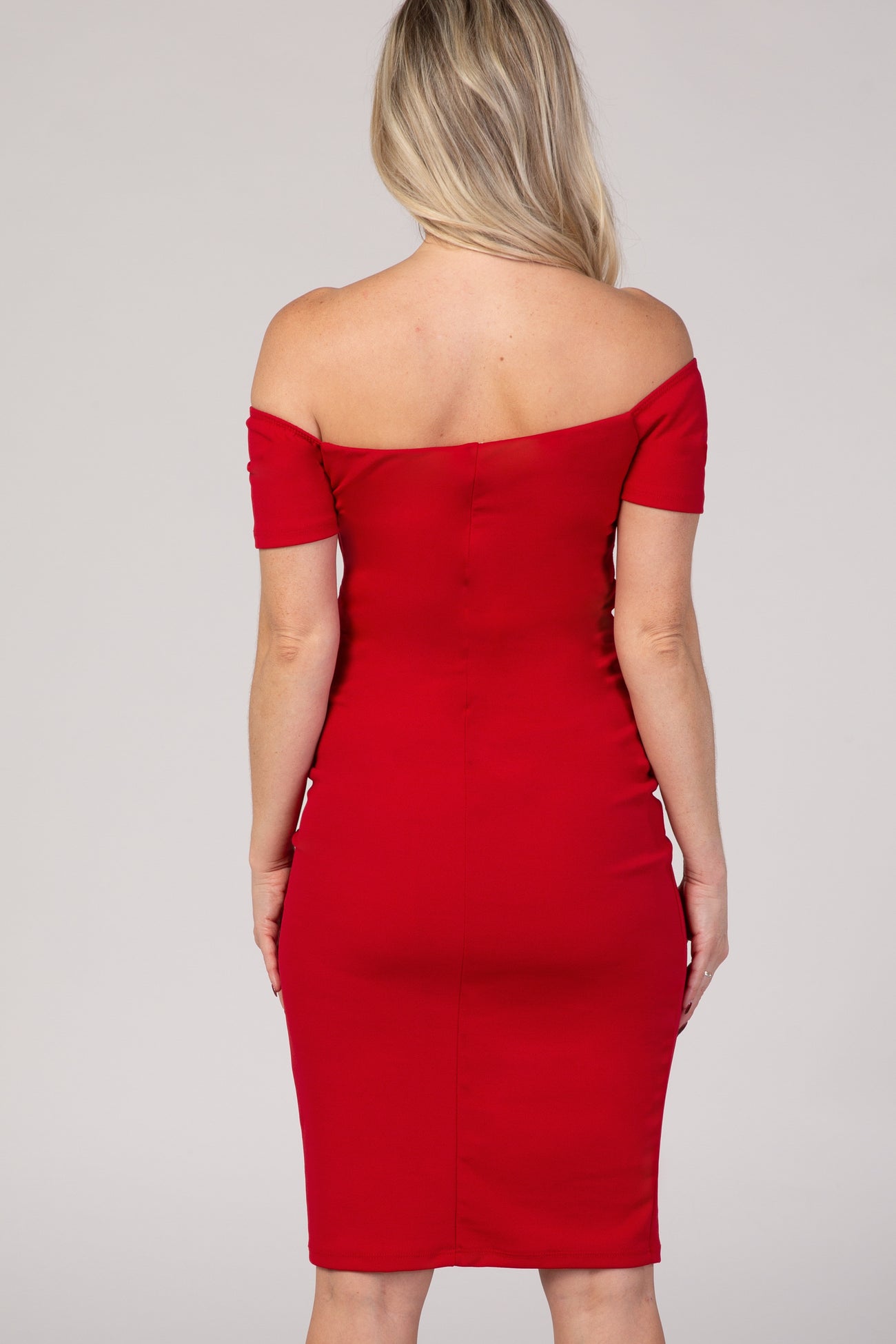 woman wearing a red off-the-shoulder maternity dress, fitted style, seen from the back