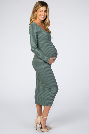 woman wearing a green striped maternity dress with long sleeves and a visible baby bump