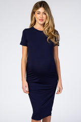 woman wearing a navy blue short sleeve maternity dress that hugs her baby bump