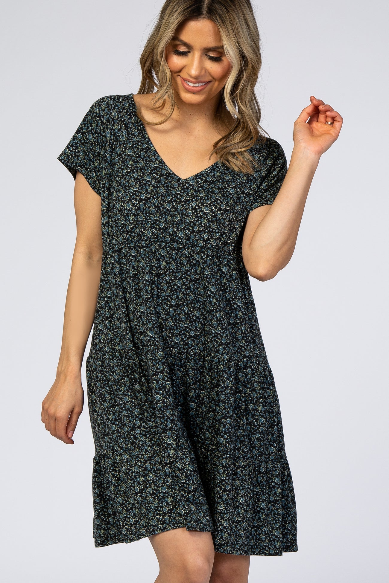 woman wearing a black and blue floral print v-neck tiered maternity dress