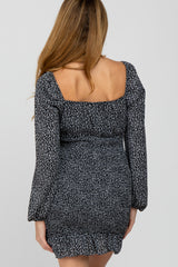 back view of woman wearing black and white floral long sleeve dress with square neckline