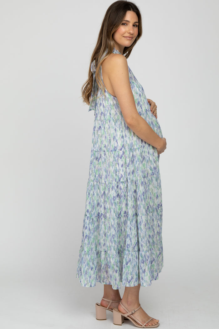 pregnant woman in a blue and purple floral tiered maternity maxi dress and tan block heels