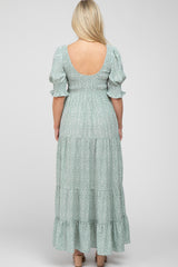 Back view of a woman wearing a sage green leopard print tiered maxi dress with puff sleeves and a smocked bodice
