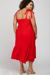 woman wearing a red maternity plus midi dress with tie straps and a ruffled hem, showing a pregnant belly