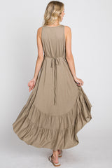 Back view of a woman wearing a sleeveless olive green maxi dress with a ruffled hem and tie waist