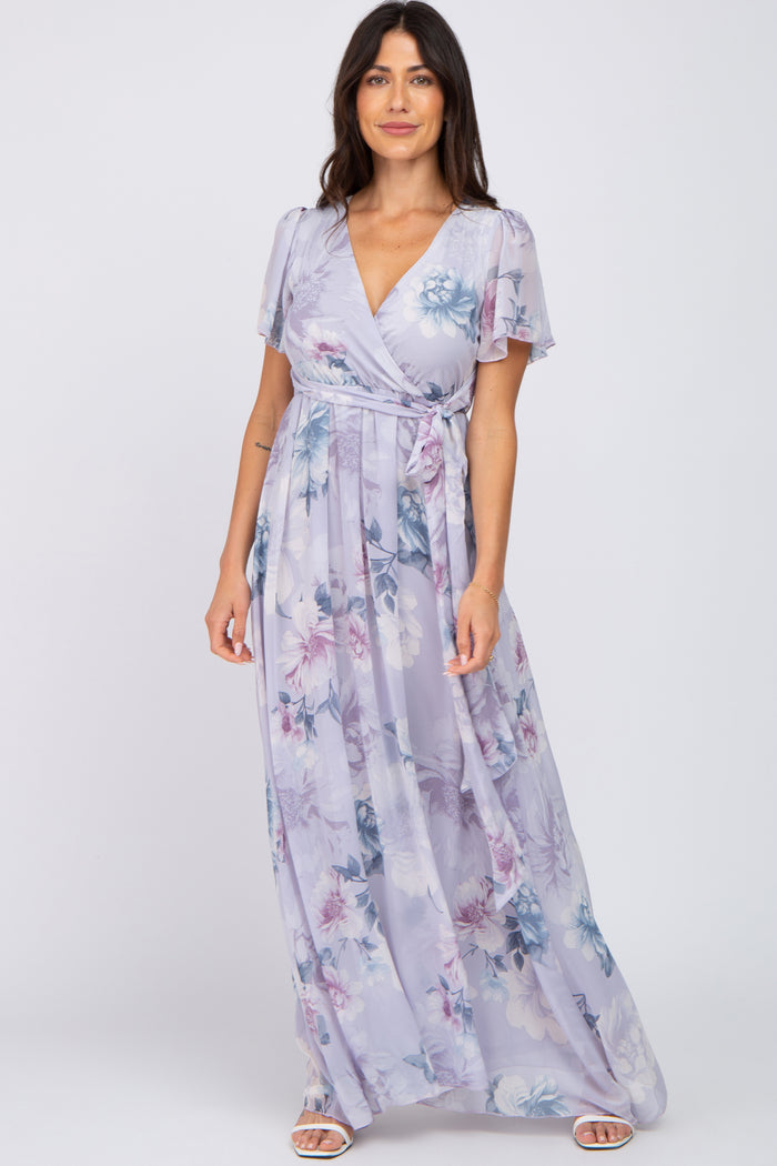 woman wearing a lavender floral wrap maxi dress with short flutter sleeves and a waist tie