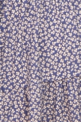 Close up of blue fabric with a white floral ditsy print and ruffled tiers
