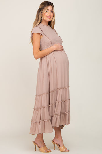 pregnant woman in a mauve smocked maternity maxi dress with ruffle details and tan heels