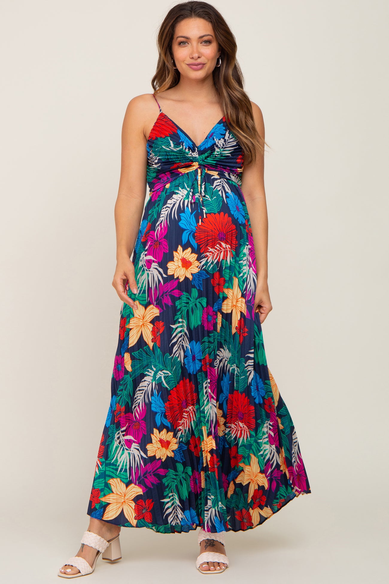 woman wearing a colorful floral maternity maxi dress with a tie detail and a visible baby bump