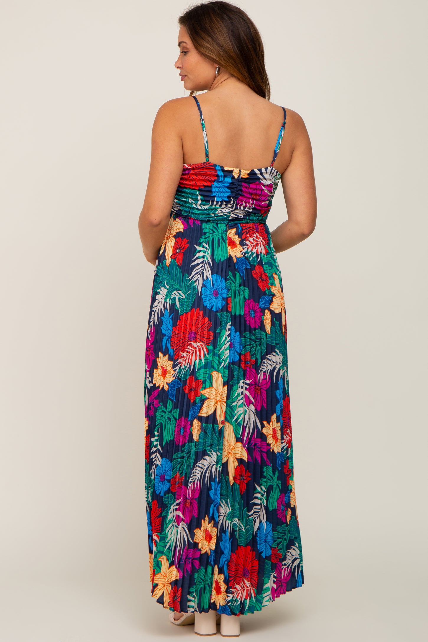 woman wearing a colorful floral maternity maxi dress with adjustable spaghetti straps, showing the back view