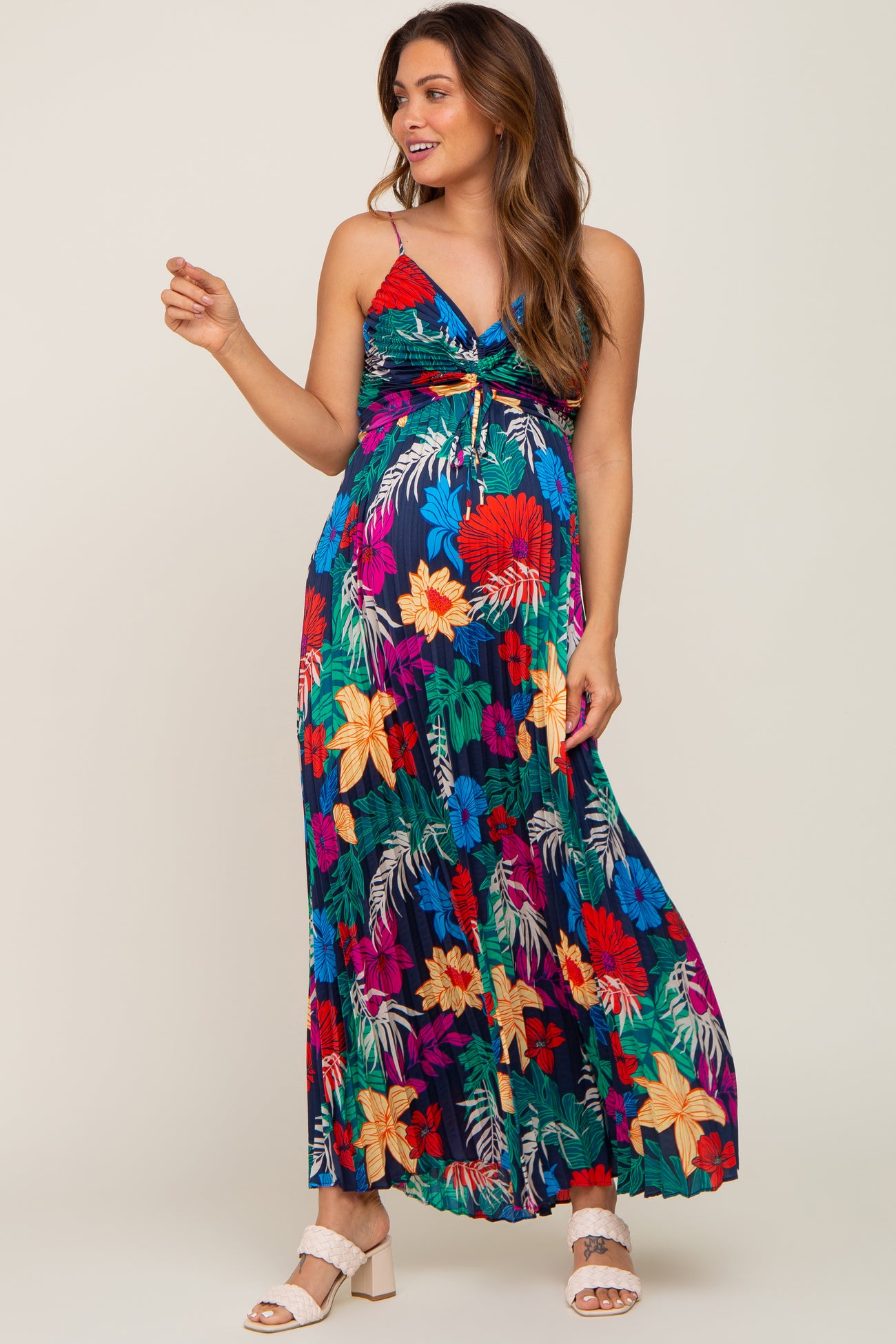 woman wearing a floral print maternity maxi dress with a halter neckline and a baby bump visible